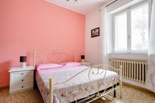 a bedroom with pink walls and a bed and a window at CASA MAFALDA - Rooms, friends and more - Affittacamere, Guest House in Senigallia