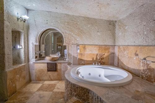 a large bathroom with a tub and a sink at Kemerhan Cave Suites in Urgup
