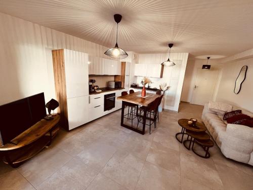 une cuisine et un salon avec une table et un canapé dans l'établissement Le Perrault Elegance, à Montpellier