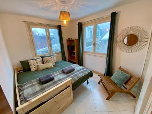 Un dormitorio con una cama, un espejo y ventanas. en Apartment Chamonix Brise du Mont, en Chamonix-Mont-Blanc