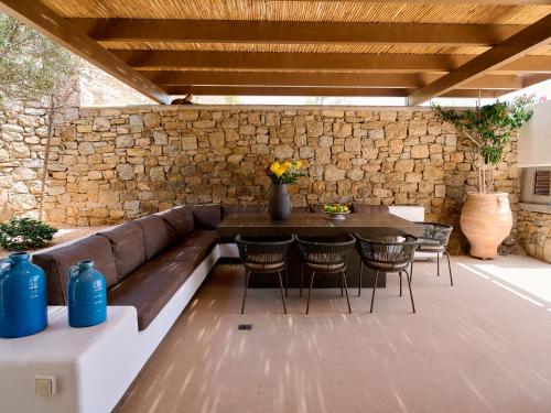 a patio with a couch and a table and chairs at Mykonos Rocks Villas & Suites in Mýkonos City