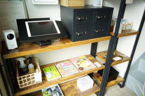a shelf with a microwave and a computer on it at wanderlust STAY in Kofu