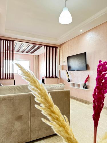 a living room with a couch and a tv at SUITOUISS - Agdal 2 - Appartements à 2 minutes de la gare de train TGV Rabat in Rabat