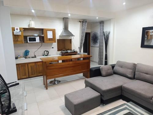 ein Wohnzimmer mit Couch und Schreibtisch in der Unterkunft Résidence Angéline 4 studios in Yassa