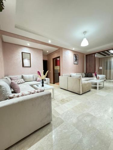 a large living room with couches and tables in it at SUITOUISS - Agdal 2 - Appartements à 2 minutes de la gare de train TGV Rabat in Rabat