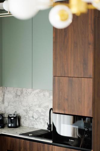 a kitchen with a stove and a microwave at Moldovei 2 Apartments by Central Park in Cluj-Napoca