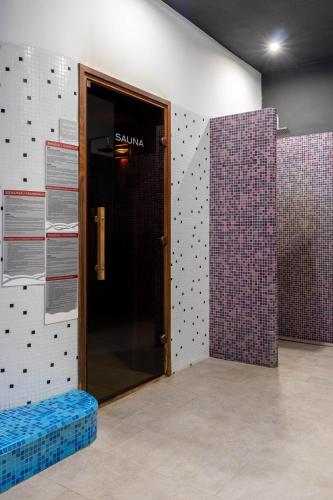 a door in a room with purple and white tiles at Altus Hotel & Spa in Praid