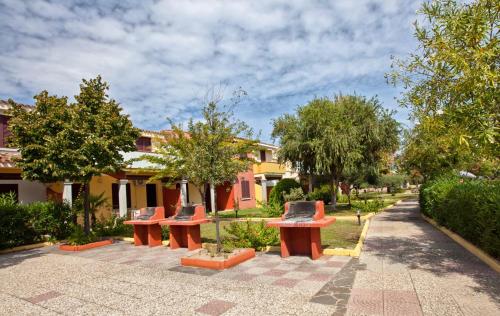 波尔托奥蒂罗卢Residence with swimming-pool in Ottiolu just 250 mt from the sea的坐在公园里的一排长椅