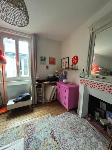 - un salon avec une cheminée et une commode rose dans l'établissement Appt 2 pers - Hyper-centre de Nantes, à Nantes