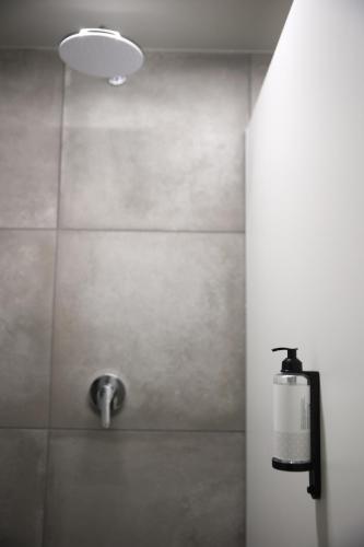 a bathroom with a shower with a soap dispenser at KY Mountain Hostel Arinsal in Arinsal