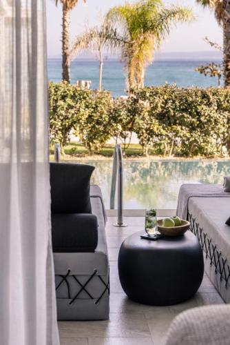 a living room with a couch and a table at Blue Carpet Luxury Suites in Pefkohori