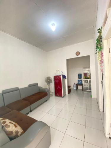 a living room with a couch and a room with a unintention at Homestay syariah off in Karawang