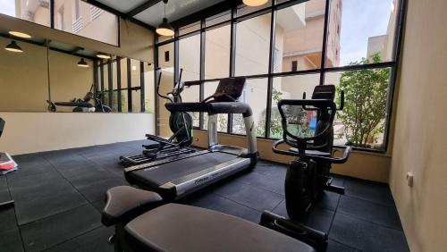 a gym with two tread machines in a room with windows at Villa 55 in 6th Of October