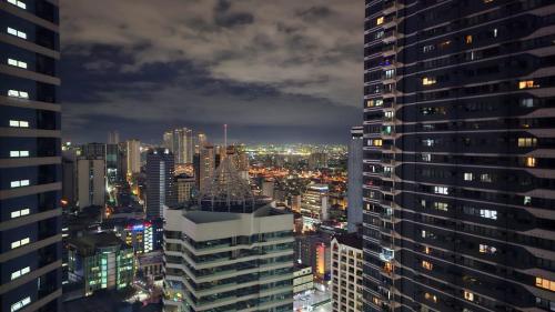 a city skyline at night with tall buildings at Awesome Value, Great Location in Manila
