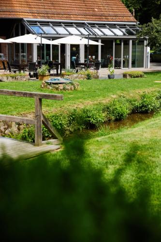a park with a picnic table and a river at Landgasthof Geiersmühle in Vielbrunn