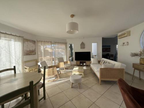 un salon avec un canapé et une table dans l'établissement PORT CAMARGUE - JOLIE VILLA POUR 6 PERSONNES CLIMATISEE AVEC JARDIN ET PARKING, au Grau-du-Roi