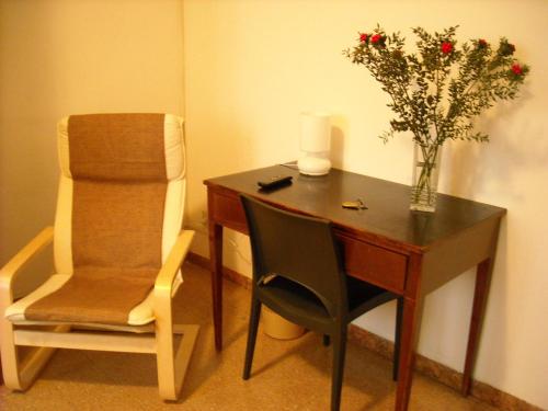 un escritorio con una silla y un jarrón de flores en B&B Sansevero Venice, en Mestre