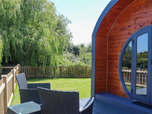 a circular building with two chairs and a window at Willow Pod in Arundel