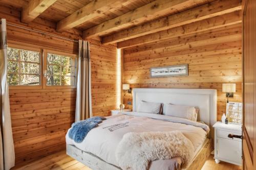 une chambre avec un lit dans une cabane en rondins dans l'établissement Vista Alpina by Mrs Miggins, à Crans-Montana