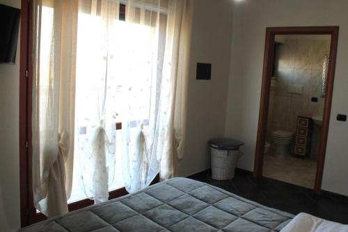 a bedroom with a bed and a large window at Giramondo LuxeFierairport in Fiumicino