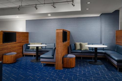 a waiting room with couches and tables and a tv at Courtyard by Marriott Myrtle Beach Barefoot Landing in Myrtle Beach