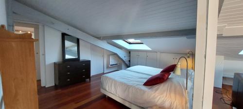 - une chambre avec un lit et un oreiller rouge dans l'établissement Burdigala Homes - Appart Montesquieu, à Bordeaux