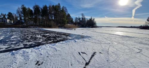 a snow covered field with trees in the background at Sjöviksvilla Sjöviksvägen in Växjö