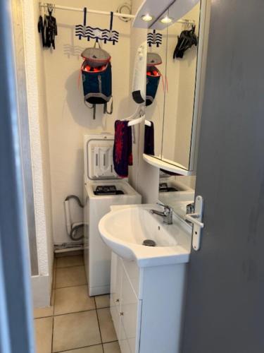 une salle de bain avec un lavabo et un miroir dans l'établissement Studio Loggia Mas de la Pinède parking, à Valras-Plage