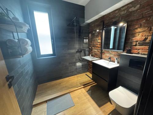 a bathroom with a sink and a brick wall at Zen Retreat Apartment in Sinaia