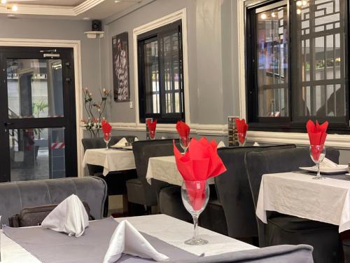 a restaurant with red flowers in a dining room at JPN SQUARE Douala in Douala