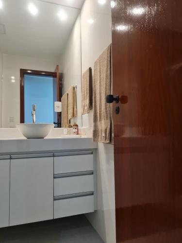 a bathroom with a sink and a mirror at Edifício Passárgada in Vila Velha