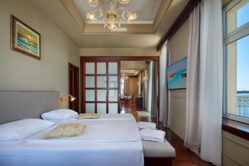 a hotel room with two beds and a chandelier at BO Hotel Palazzo in Poreč