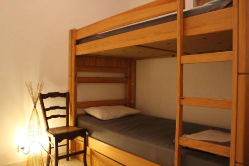 - une chambre avec 2 lits superposés et une chaise dans l'établissement Maison 4 pièces 6 couchages Saint Georges d'Oléron SGO000-652, à Saint-Georges-dʼOléron