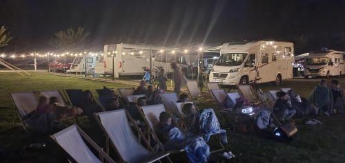 a group of people sitting in chairs in a field at night at Catalpa Camp Ośrodek Rekreacyjno-Wypoczynkowy nad jeziorem Gopło in Piotrków Kujawski