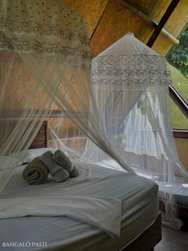 a teddy bear laying on a bed with mosquito nets at Sitio Simple Life in Ubatuba
