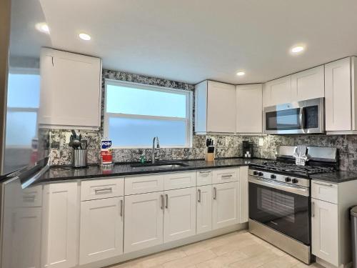 a kitchen with white cabinets and a window at Siesta Heron Suites & Villas in Siesta Key