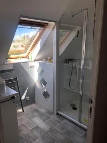 La salle de bains mansardée est pourvue d'une douche. dans l'établissement lesmainsdelange, à Concarneau