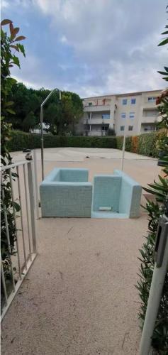 un banc bleu assis devant un bâtiment dans l'établissement T3 Lumineux et convivial, Parking Privé, à Montpellier