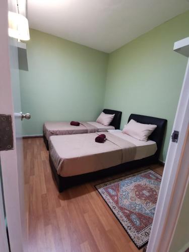 two beds in a room with a door open at AEA Staycation at Prima Homes Matang in Kuching
