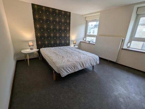 - une chambre avec un lit, 2 tables et 2 fenêtres dans l'établissement Appartement tout équipé de 2 chambres a charmes, à Charmes