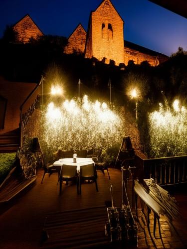 a table and chairs in front of a building with lights at Urlaubsresidenz Schlossblick in Colditz