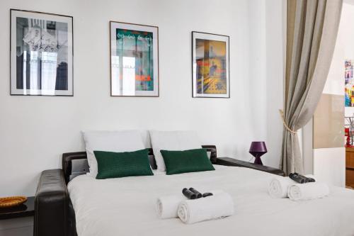 une chambre avec un grand lit blanc avec des touches vertes dans l'établissement BM-Cozy Elegance in the Marais, à Paris