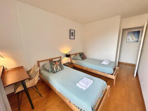 a room with two beds and a desk and a piano at L'Aérien- Parking- Centre ville - Calme in Toulouse