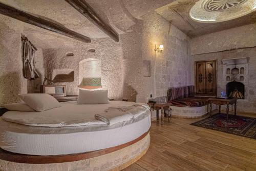 a bedroom with a large bed in a stone room at Kemerhan Cave Suites in Urgup