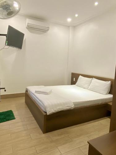 a bedroom with a bed with white sheets at Khách Sạn Hoa Phượng in Ho Chi Minh City