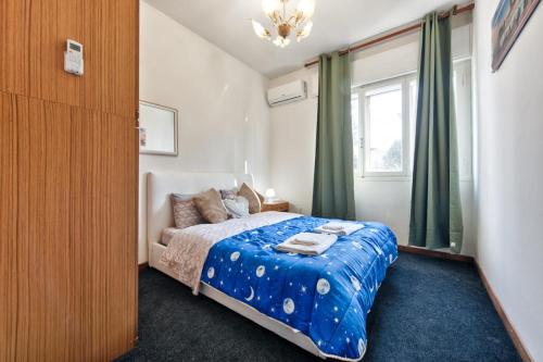 a bedroom with a bed with a blue comforter and a window at Cozy Miranese Venice Apartment in Chirignago