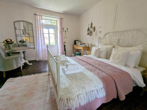 une chambre avec un grand lit avec une couverture rose dans l'établissement Sous le Chateau, à Jumilhac-le-Grand