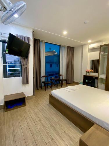 a hotel room with a bed and a flat screen tv at Khách Sạn Hoa Phượng in Ho Chi Minh City