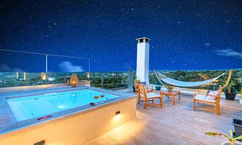 una terrazza panoramica con piscina di notte di Ferienhaus Für 12 Personen In Agia Paraskevi Nordkreta, Kreta Nordküste Kretas a Georgioupolis