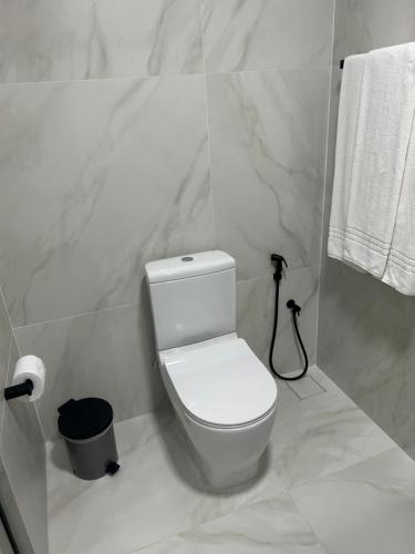 a white bathroom with a toilet and a trash can at Américas Benidorm Hotel in Rio de Janeiro